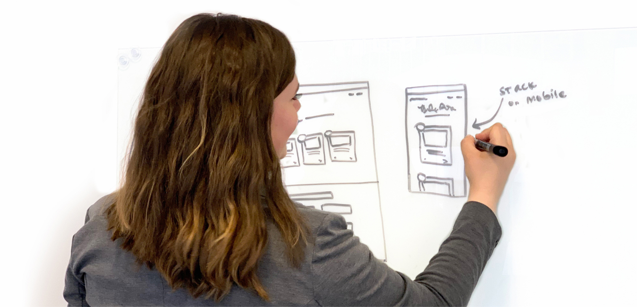 Image of Matie Natov sketching a landing page wireframe on whiteboard.